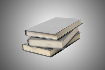 The opened book lies next to a stack of closed books on a gray background.