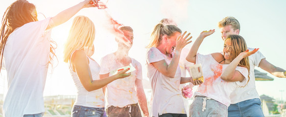 Happy friends having party with powder colors at holi fest - Young people having fun together at...