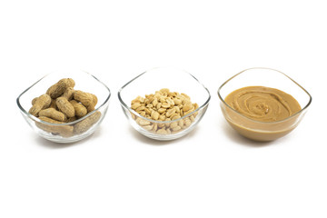 Three bowls with peanuts and peanut butter isolated on white background. 