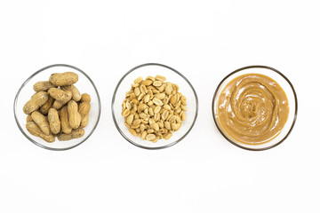 Nuts and peanut butter in bowls isolated on white