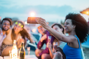 Happy friends taking selfie with smartphone at beach party outdoor - Young people having fun at...