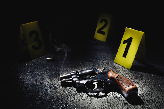 gun with smoke on the floor and evidence markers, high contrast image