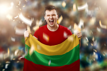 A Lithuanian fan, a fan of a man holding the national flag of Lithuania in his hands. Soccer fan in the stadium. Mixed media