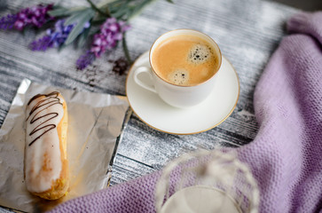 Cup of coffee and sweater on a wooden background