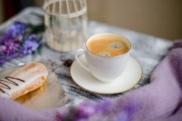 Cup of coffee and sweater on a wooden background
