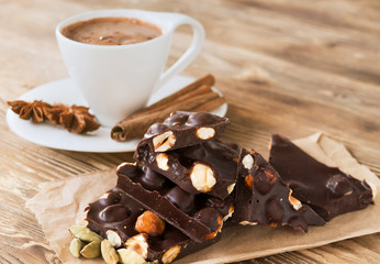 Coffee break with cinnamon and anise stars, cardamom on a rustic table and dark chocolate with...