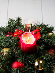 Christmas spruce branch wreath with candle on the wood board