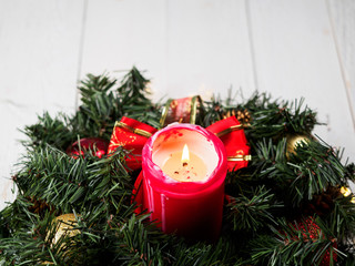 Christmas spruce branch wreath with candle on the wood board
