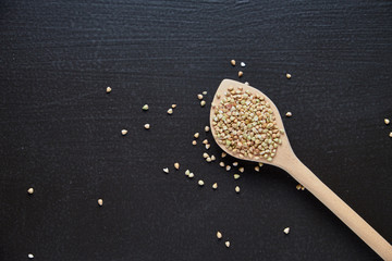 Raw green buckwheat on a black background.