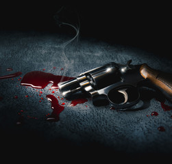 crime scene concept with a gun on a blood puddle, high contrast image