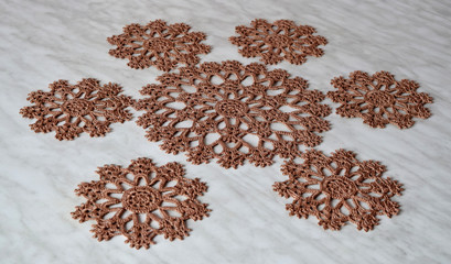 Brown hand hooked coaster. Knitted holders for hot work.