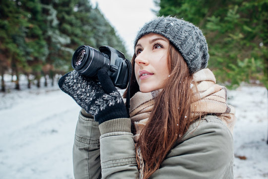 Young photographer takes pictures of winter forest