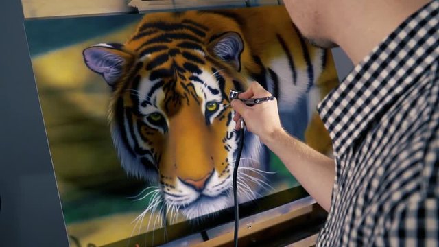 The artist is painting the painting with aerography