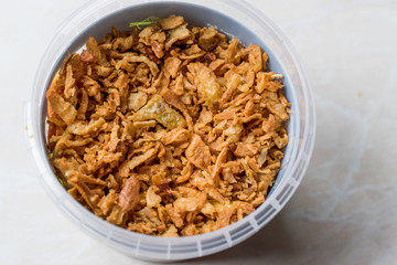 Fried Crispy Onion Flakes in Plastic Package Bowl.