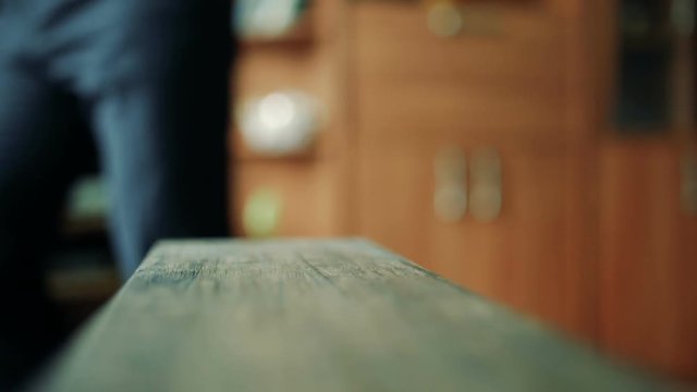 The groom puts on a bow-tie in a shirt, standing in a room