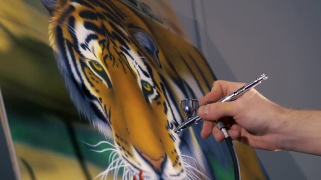 The artist is painting the painting with aerography
