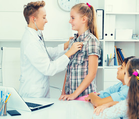 Young male doctor in uniform with children