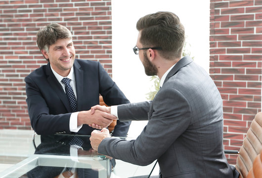 greeting handshake of colleagues at the desk