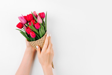 Female hands holding a bouquet of tulips wrapped in paper