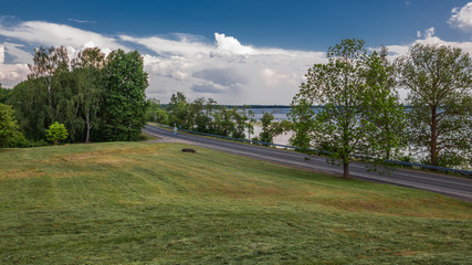 Obraz premium summer countryside. View from a sloping hill on a country asphalt road along the coast of a large lake
