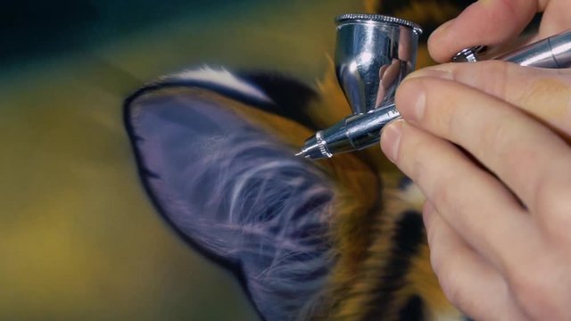 The artist is painting the painting with aerography
