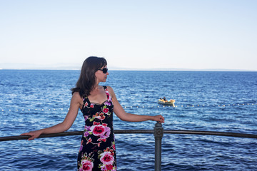 Young woman on sea cost. Sunny summer day.