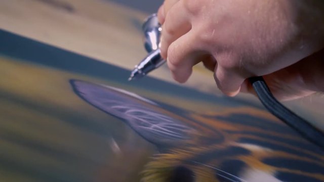 The artist is painting the painting with aerography