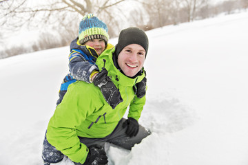 Fototapeta na wymiar Father And Son In Snowy Landscape