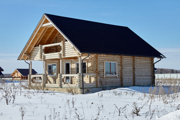 Wooden house at winter, unfinished construction, sunny day