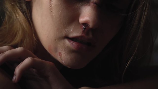 A girl with a broken face sighs and cries