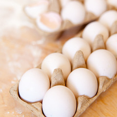 Home cooking still life of eggs in box. Organic products on wooden table.
