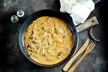 Classic beef Stroganoff in white sauce in a cast-iron frying pan.