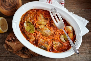 White sea fish stewed with onions and carrots in tomato sauce.