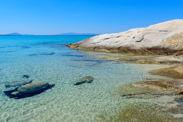 Azure blue sea water and rocks. Mikri Vigla beach on Naxos island, Greece.