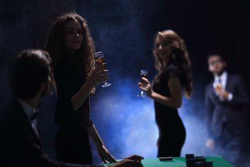 young people with glasses of wine in a casino