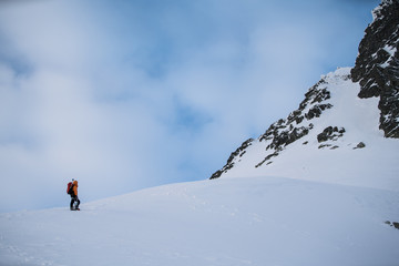 Naklejka na ściany i meble Men hiking in high snowy mountains in winter