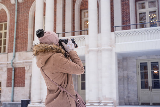 Young female tourist takes photos of architecture