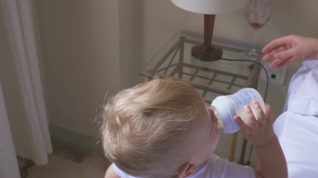 A one year old kid drinks milk, and his mother drinks wine. The concept of a dysfunctional family and alcoholism