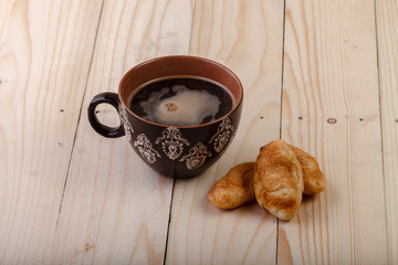 brown cup of hot tea and croissants 