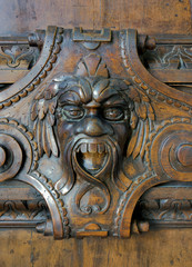 Carved gargoyle in wooden door in Doge's palace, Venice, 2017.