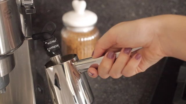 woman is making hot milk coffee machine and hand style