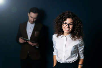 the woman is the leader in the team. curly brunette with glasses