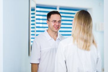 Fototapeta premium Two Male and Female Doctors or Nurses Standing Inside Hospital Building.
