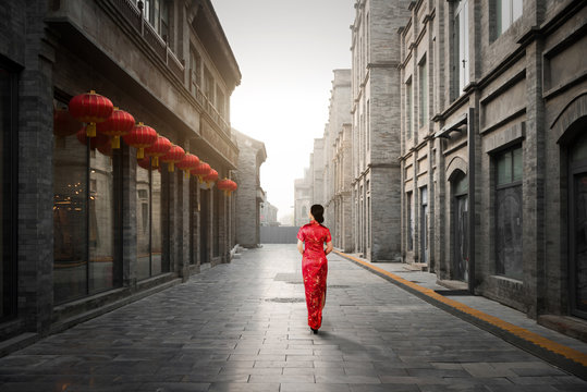 Asian young woman in old traditional Chinese dresses in Hutong village in Beijing, China.