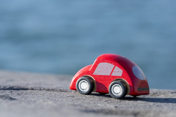 Obraz na płótnie Canvas Toy Car near the sea. Travel, tourism, holiday and adventure concept.