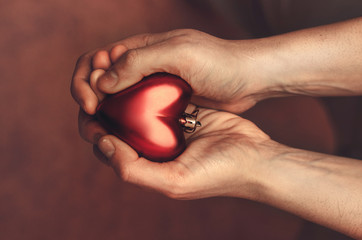 Red heart in man's hands, view from above