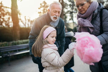 Grandparents having fun with their grandchildren in city park.