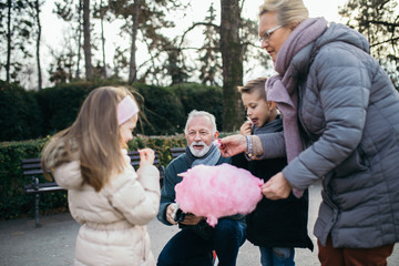 Grandparents having fun with their grandchildren in city park.