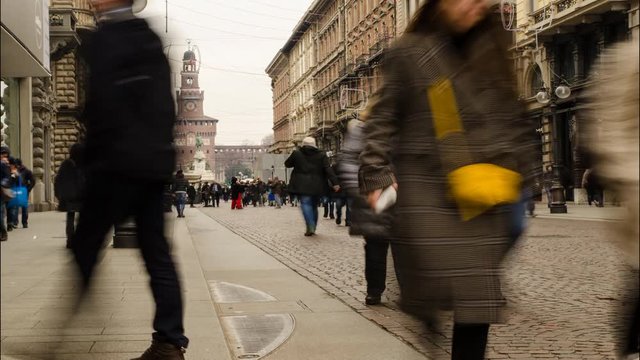 Milan, Italy 31 December at 14:50. Time laps in Via Dante full of tourists who visit the city awaiting the New Year celebrations. In the background the faade of the Sforza castle.
