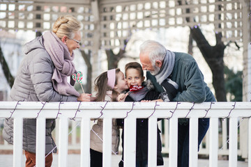 Grandparents having fun with their grandchildren in city park.